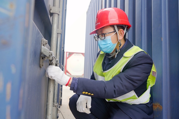 南宁国际铁路港货运员正在集装箱货线核对跨境集装箱施封情况。陈星宇摄