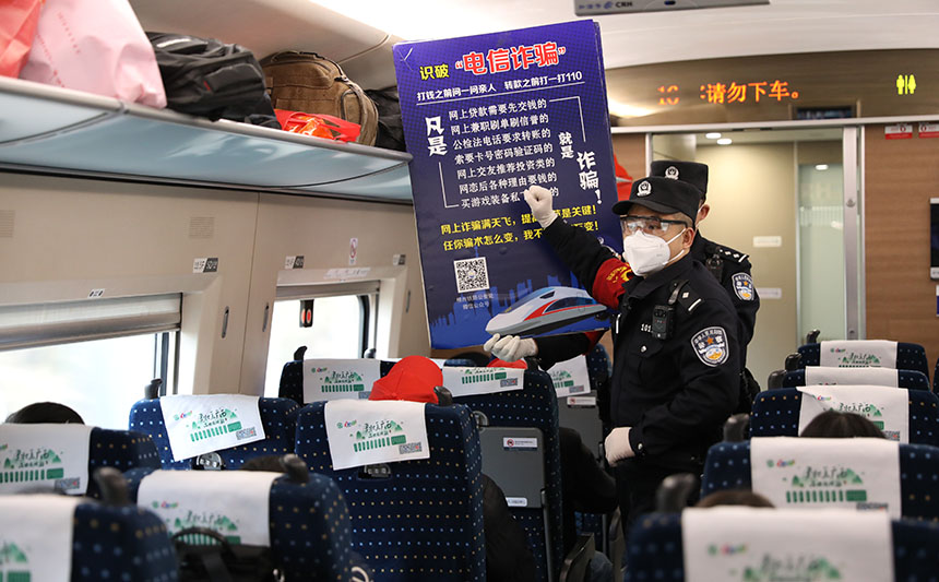 G2961次列车乘警向赴粤务工人员宣传反诈知识。胡玄德摄