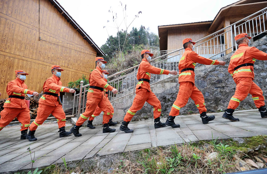 云南森林消防总队普洱支队指战员正在对苗寨的木结构建筑进行巡防。