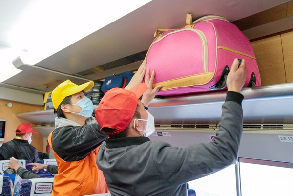 青年志願者幫助務工人員搬運行李。胡利峰攝