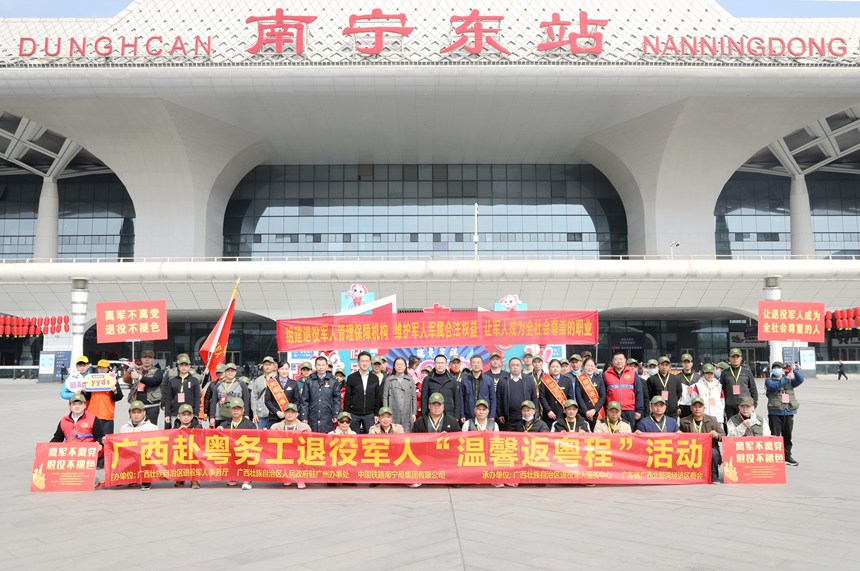 返岗退役军人与工作人员在南宁东站广场上集体合照。陈健摄