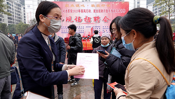 2月2日，工作人员在深圳宝安·河池都安2023年“春风行动”招聘会上与求职者洽谈。
