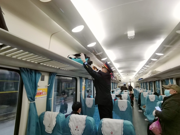 宁祖全帮助旅客放置行李。唐国标摄