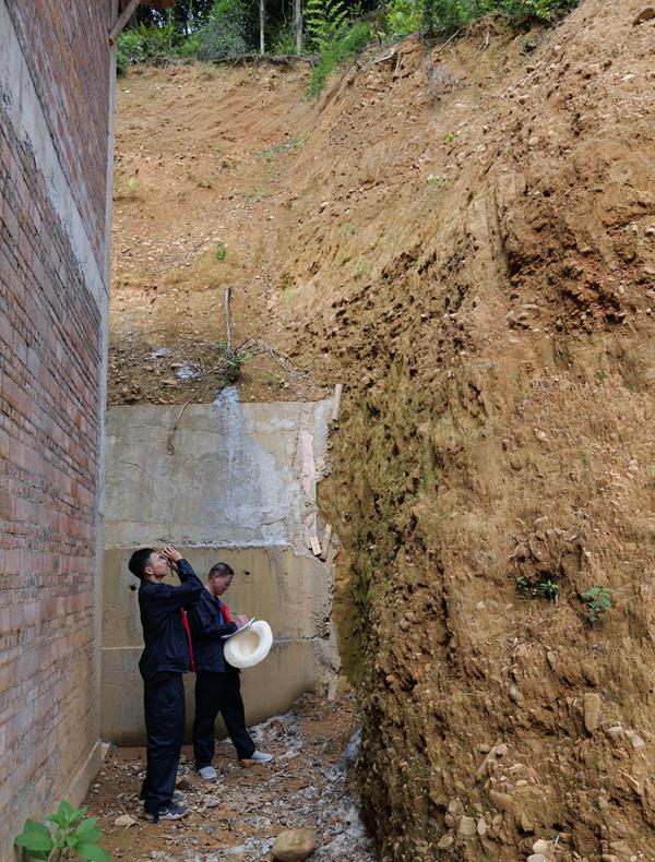 广西地质工作者在民房旁开展地质灾害调查