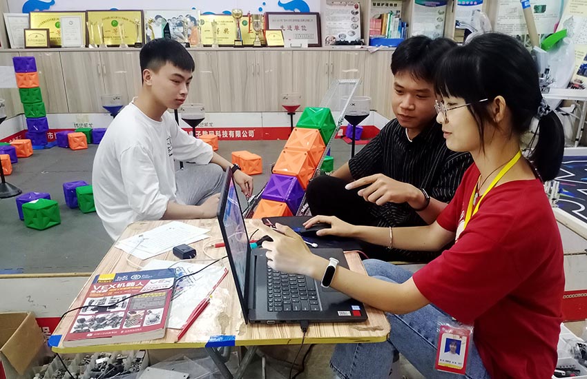 钟山县职业技术学校学生杨静容（右一）指导学校创客团队成员开展机器人编程训练。陈小武摄