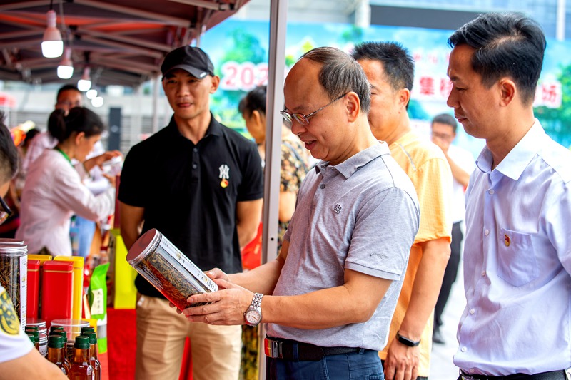 桂林市供销社相关领导在“供销大集”活动现场了解专业合作社农户产品。