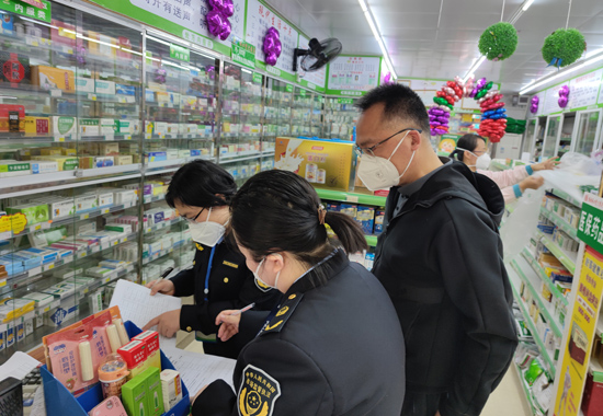 桂林市市场监管局执法人员检查药店经营台账。