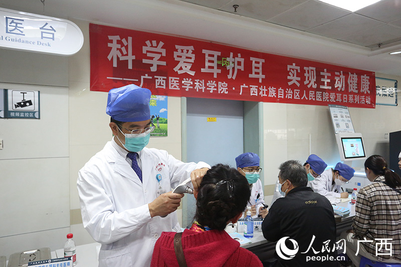瞿申红在义诊现场为患者检查耳朵。人民网记者 彭远贺摄