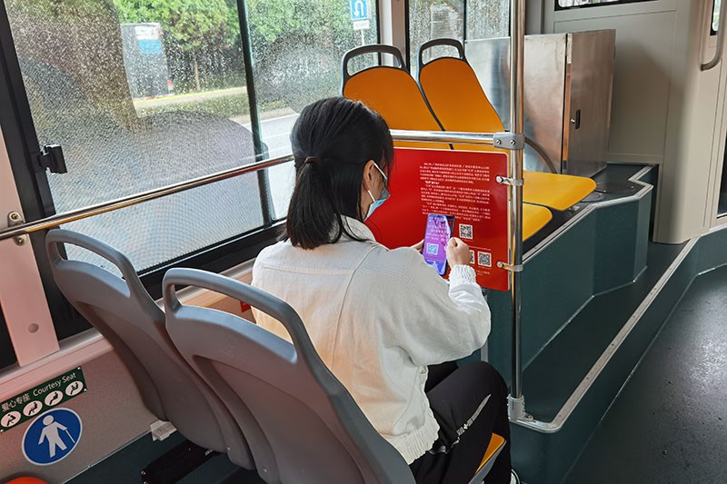 乘客在公交车上体验线上“红湾”。广西党员教育中心供图