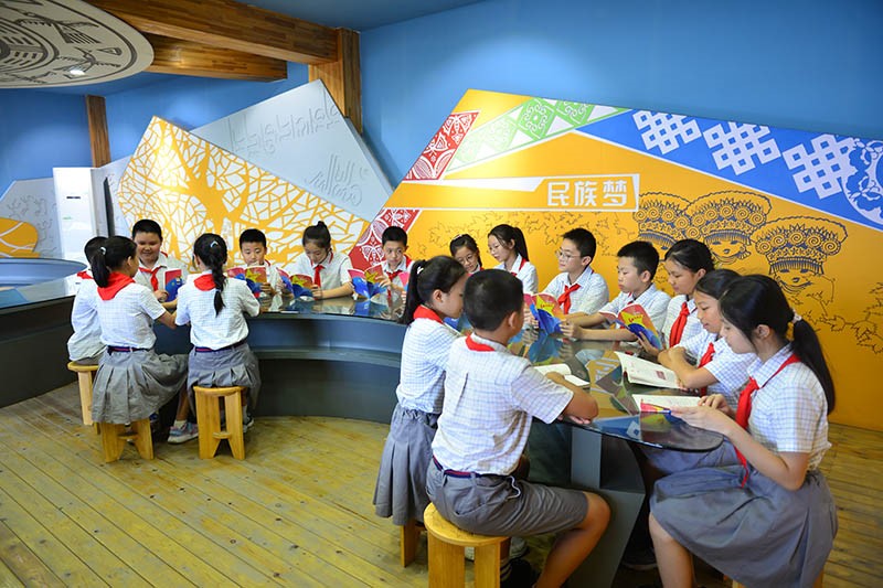柳州市民族实验小学的学生们阅读《红色传奇》读本。柳州市党员教育中心供图