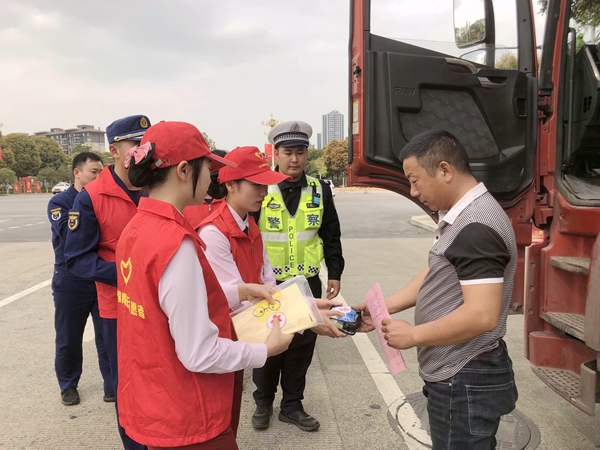 志願者們開展關愛卡車司機志願行動，向卡車司機贈送長途洗漱包。
