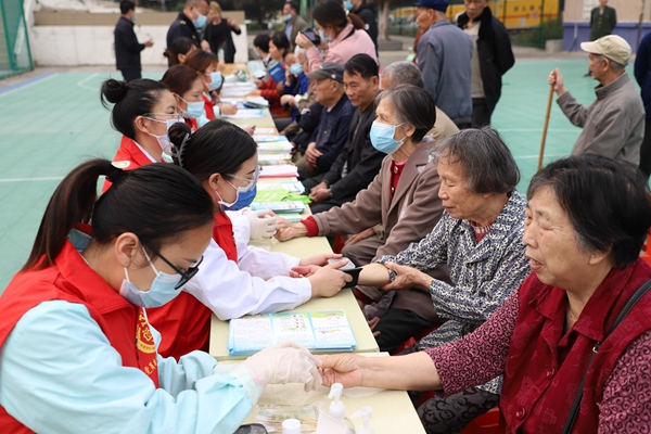 医务人员帮助老人量血压。