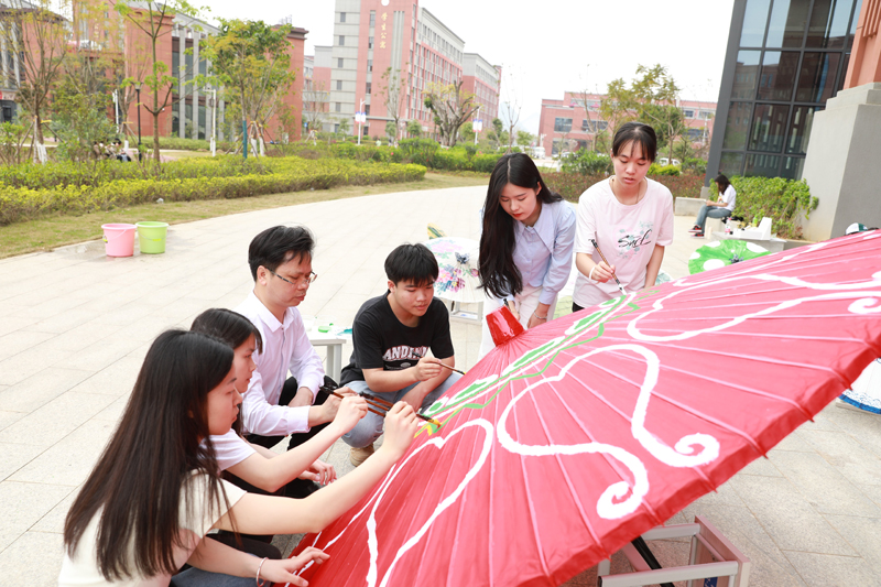 韦军民大师与学生共同绘制油纸伞。秦俊峰摄