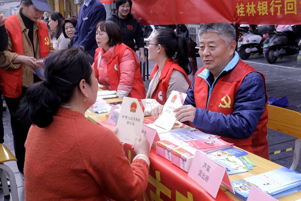 图为桂林市审计局工作人员向市民宣传《中华人民共和国审计法》