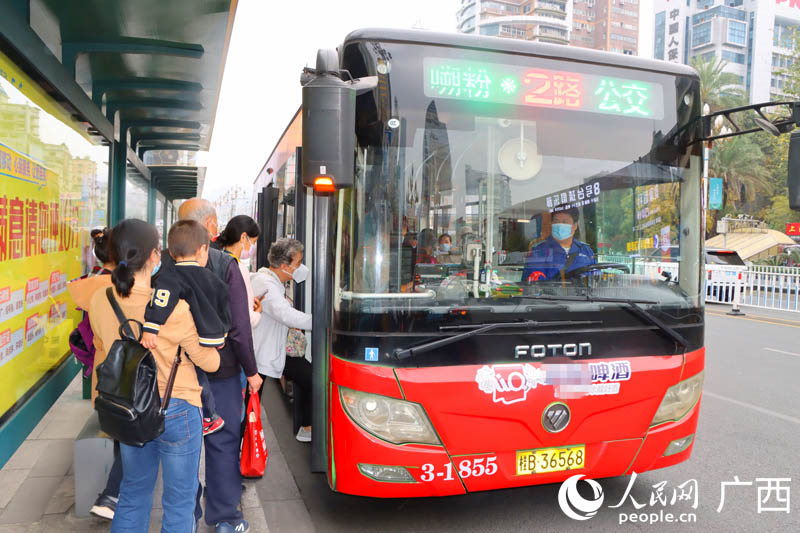 人们在柳州市区排队乘坐“嗍粉”专线公交车。人民网 付华周摄