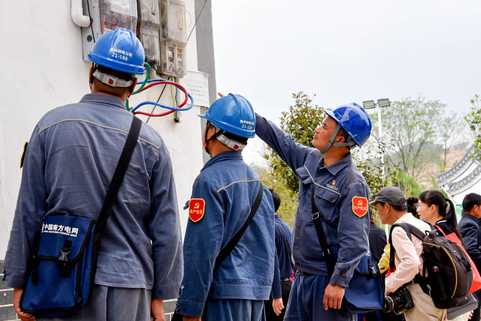队员检查供电线路并向茶农宣传安全用电知识。何华文摄