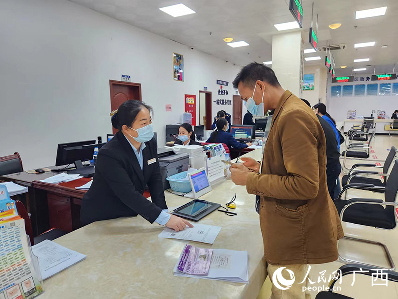 良庆区政务办工作人员正为来访群众办理相关业务。
