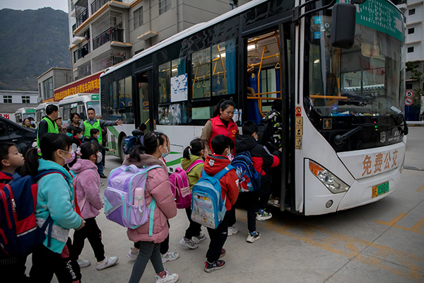 圖為龍岩社區“黨員先鋒服務站”黨員們正在護送社區學生乘公交車前往學校。黃麗華攝
