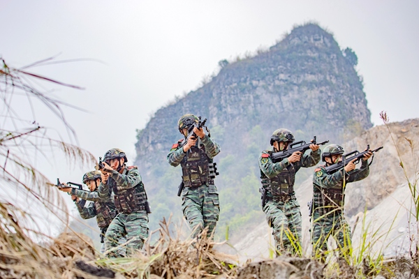 武警官兵运用战术队形搜索目标。