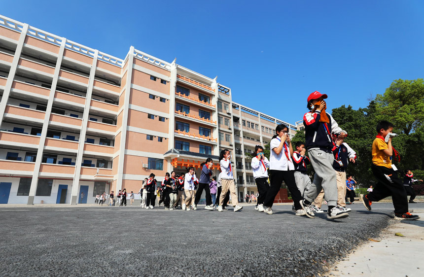 学生在老师的指挥下进行应急避险逃生演练。