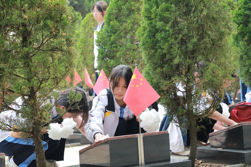 学生在擦拭墓碑