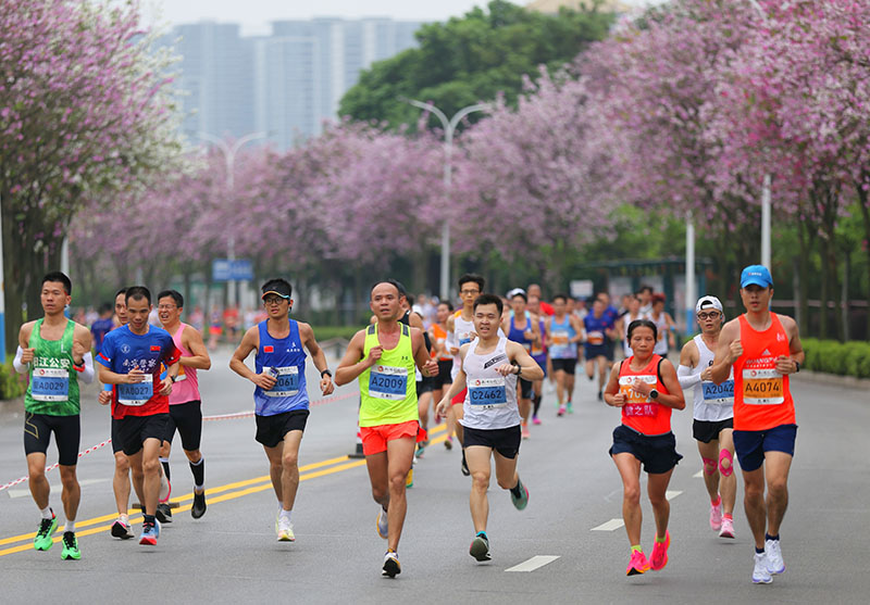 參賽選手在紫荊花道中奔跑。王緝寧攝