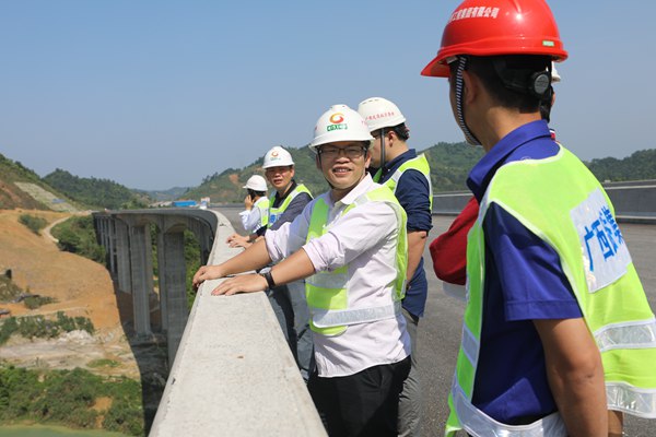 图为韦红亮在调研高速公路建设情况