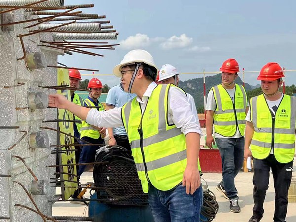 图为韦红亮在检查桥梁生产质量情况