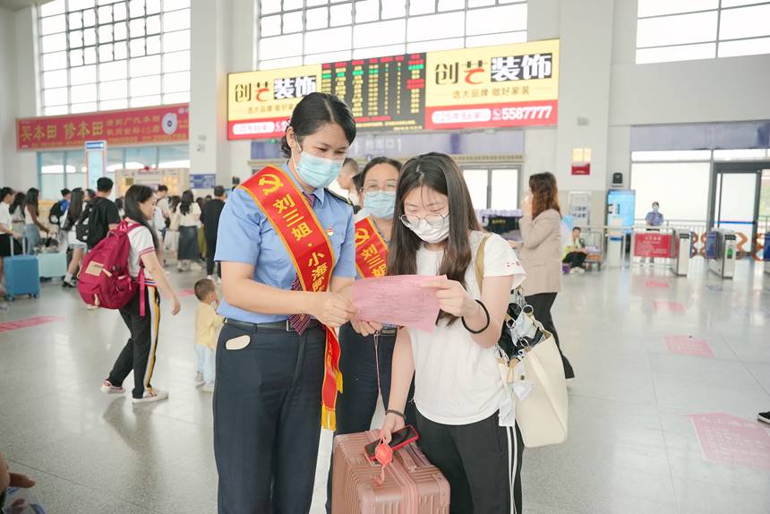 钦州东站“刘三姐·小海豚”志愿者服务队邀请候车旅客观看演出。吴柯荣摄