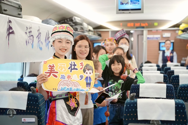 列车工作人员与旅客一起唱山歌。曹烁摄