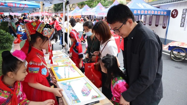 玉州区在泉塘巷开展民族手工艺品、绘画义卖。