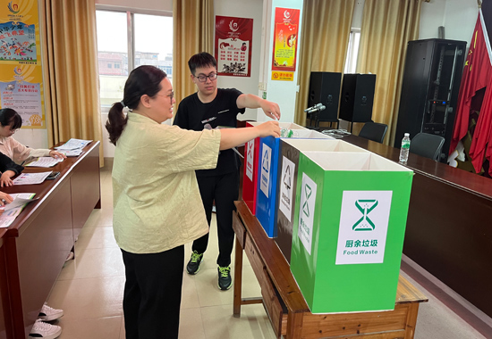 居民认真学习垃圾分类投放。