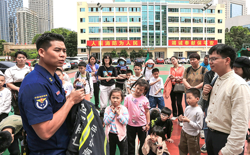 消防员向大家介绍报警器的功能。杨进摄