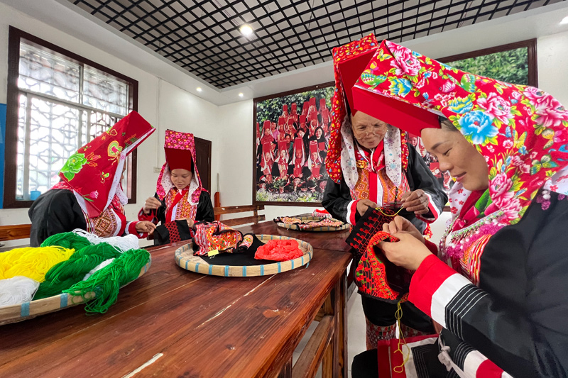 大板瑶姐妹们正在一针一线地绣着衣服、腰带及挎包上的花边图案。