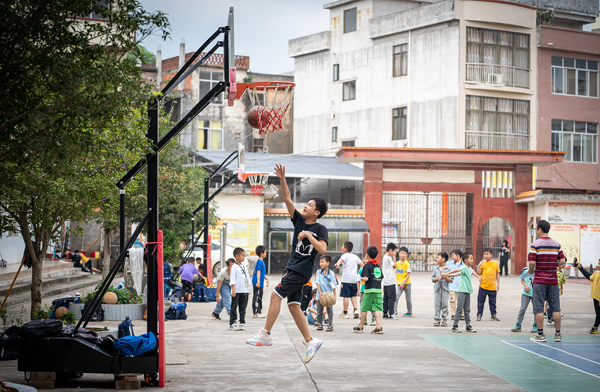 學生在趣味籃球課上練習投籃。