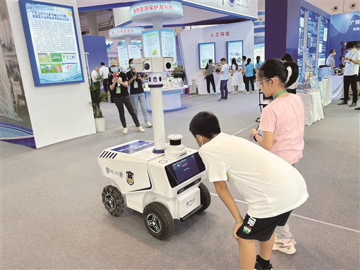 5月20日，在南宁启动的2023年广西科技“两周一展”活动上，两名小朋友正好奇地观察着一个机器人。南国早报记者卢盈摄
