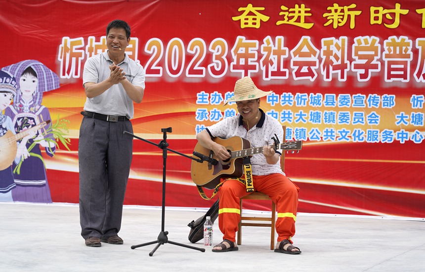 5月17日，在忻城縣大塘鎮六安村開展社會科學普及活動周暨全民藝術普及月基層文藝演出活動。圖為社科普及志願者為六安村群眾演繹自創小品