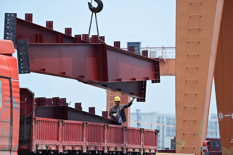 工人在吊装钢结构将运往项目建设现场。黄蕊摄