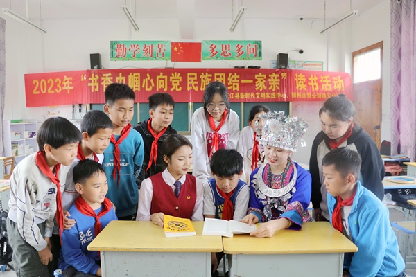“金花班组”成员与同学们共读民族团结书籍。