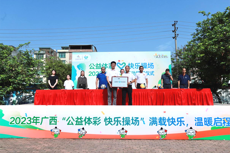 南寧市體育局副局長甘前嶺向寧武小學校長陸速鳴授予“公益體彩 快樂操場”活動牌匾。廣西體彩供圖