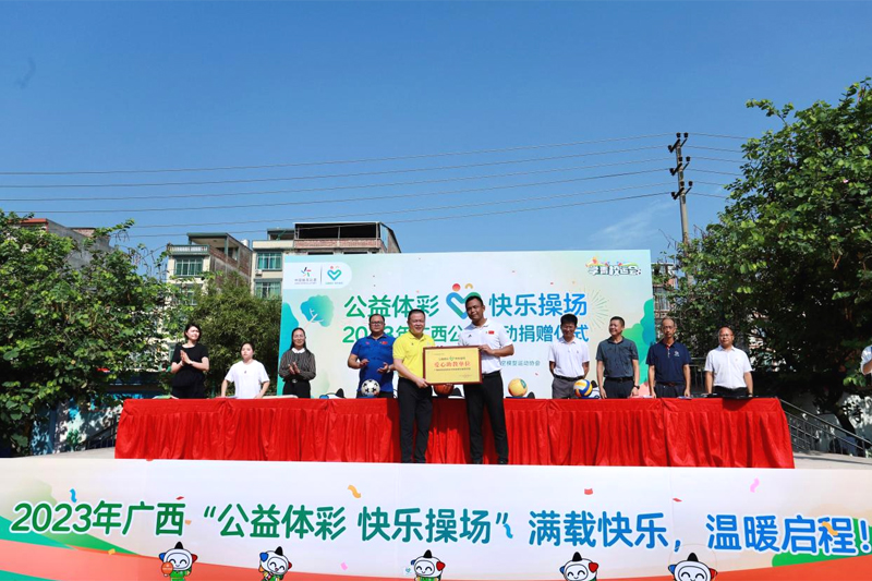 廣西體育彩票管理中心副主任廖學志向廣西體育高等專科學校體育與教育學院黨總支書記覃琳授予“愛心助教單位”牌匾。廣西體彩供圖