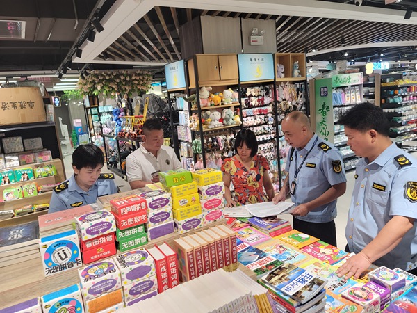 图为执法人员对超市负责人进行法制宣传。班华俭摄