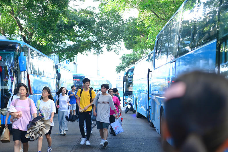 柳州铁一中学城站校区考生陆续上送考车。黄蕊摄