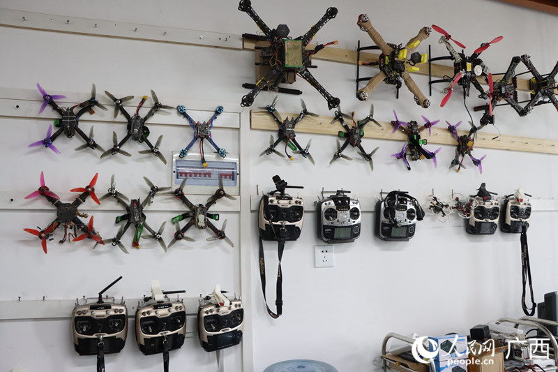 无人机实验室的墙上挂满机器。人民网 覃心摄