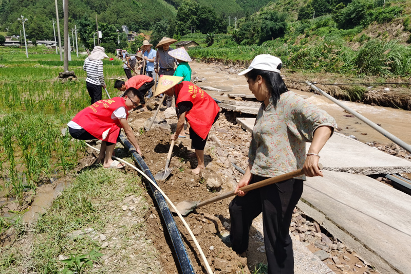 贺州市八步区驻村工作队员与群众抢修水利设施。
