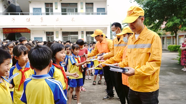 职工为小学生们发放铁路安全知识和爱路护路宣传资料。李慕传摄