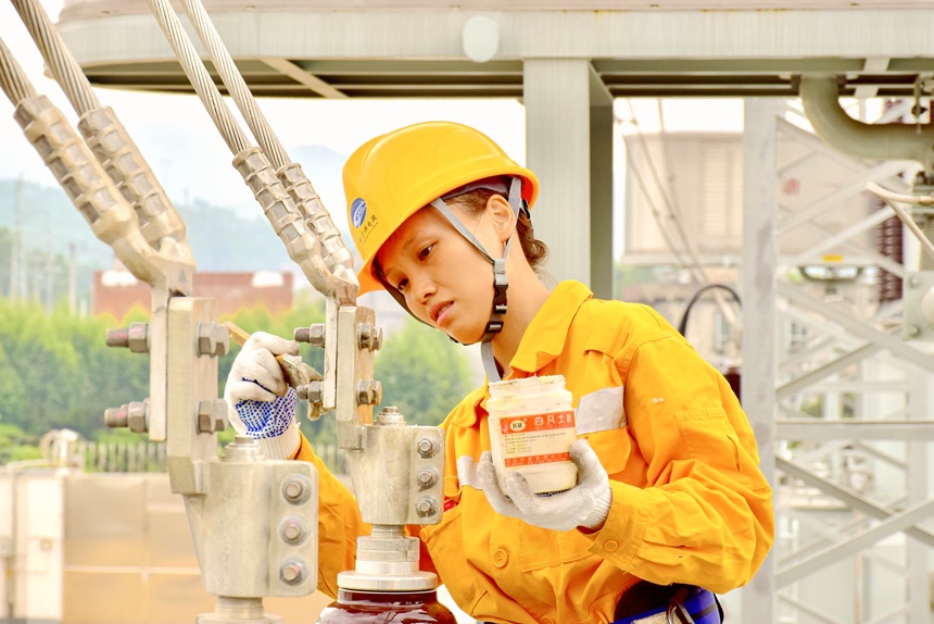 青年職工在對變壓器線夾涂抹凡士林。黃海源攝