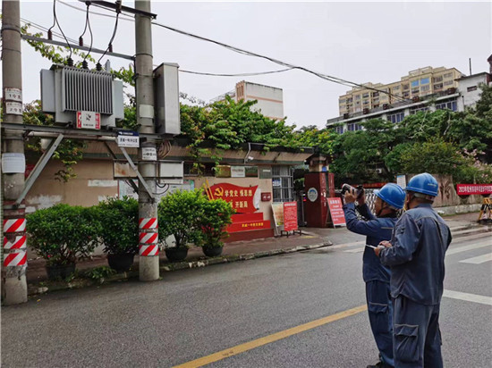 南方电网广西钦州灵山供电局灵城供电所党员服务队对灵山县灵城一中的一中2号变压器开展测温检查。（兰国）