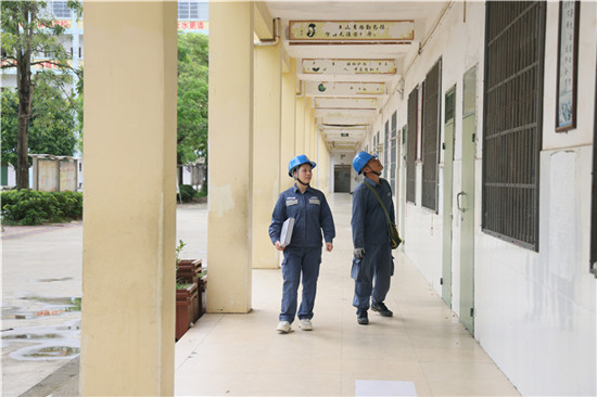 南方电网广西钦州灵山供电局新圩供电所党员服务队对灵山县云洲中学保供电点的配电线路设备开展巡视维护。（陈心诚）