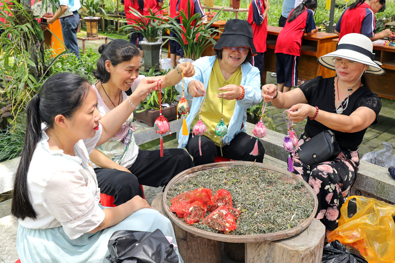 游客在祖立村包香囊。冼新梅摄影
